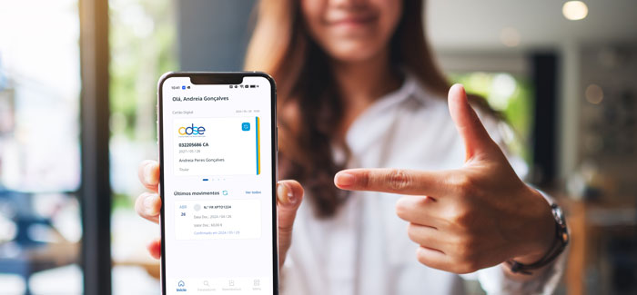 Mulher a mostrar o ecrã de telemóvel, com o cartão digital da ADSE, na app MyADSE